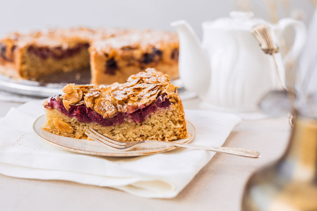 Ein Stück veganer Kirschkuchen mit Ahorn-Mandel-Topping auf einem Kuchenteller