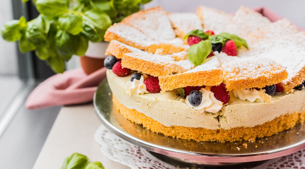 Limetten-Basilikum-Torte von Oma Anni von Kuchentratsch mit frischem Basilikum im Hintergrund